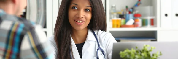 Krásná černá usmívající se lékařka talk s — Stock fotografie