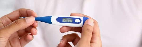 Manos de una doctora sosteniendo un termómetro —  Fotos de Stock