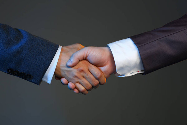 Man in suit shake hand as hello in office closeup