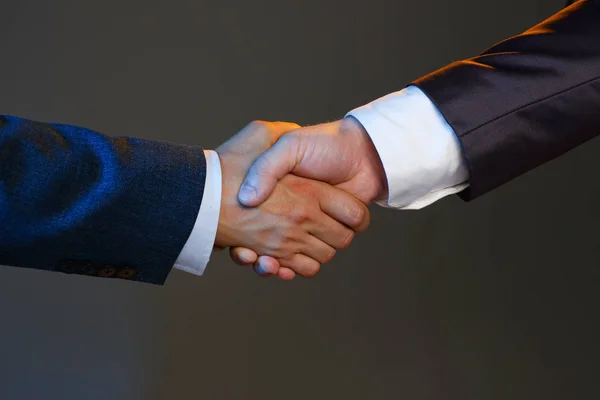 Man in suit shake hand as hello in office closeup