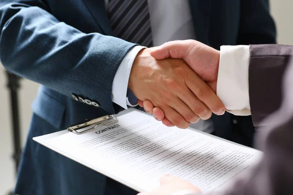 Man in suit shake hand as hello in office closeup