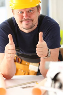 Çalışan sarı kask gösterisinde gülümseyen onaylamak işareti