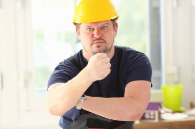 Sarı kask poz içinde gülümseyen komik işçi