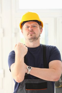 Sarı kask poz içinde gülümseyen komik işçi