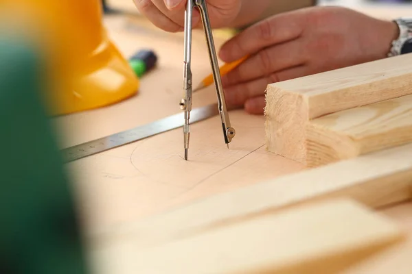 Bracci di lavoratori che elaborano un piano strutturale su carta in scala — Foto Stock