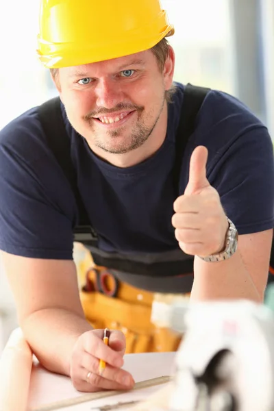 Lächelnder Arbeiter mit gelbem Helm zeigt Schild — Stockfoto