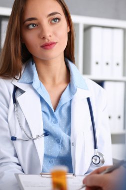 Kollarında güzel gülümseyen kadın doktor tutun