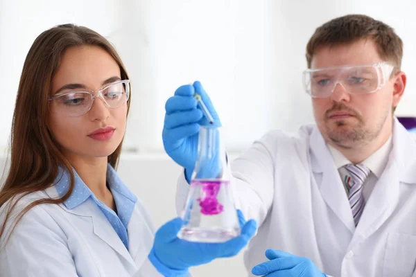 Technician hold in arms in protective gloves sample bottle — Stock Photo, Image