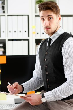 Takım elbiseli yakışıklı adam tutun silah gümüş kalem ve yastık
