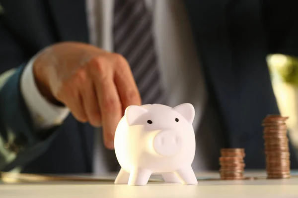 Hand businessman putting pin money into pig — Stock Photo, Image