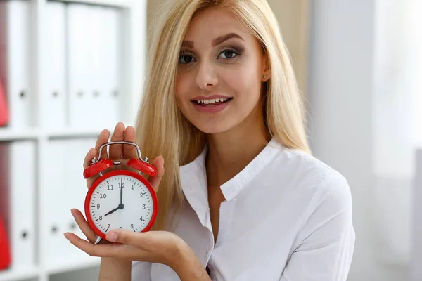 Mujer de negocios sonriente sosteniendo en la mano la alarma — Foto de Stock