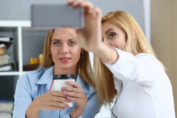 Twee vrouwelijke ondernemers in het kantoor glimlach en doen selfie — Stockfoto