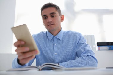 Bir işadamı yeni bir akıllı telefon elinde tutuyor.