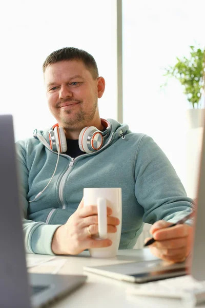 Bonito sorrindo estudante do sexo masculino usando online — Fotografia de Stock