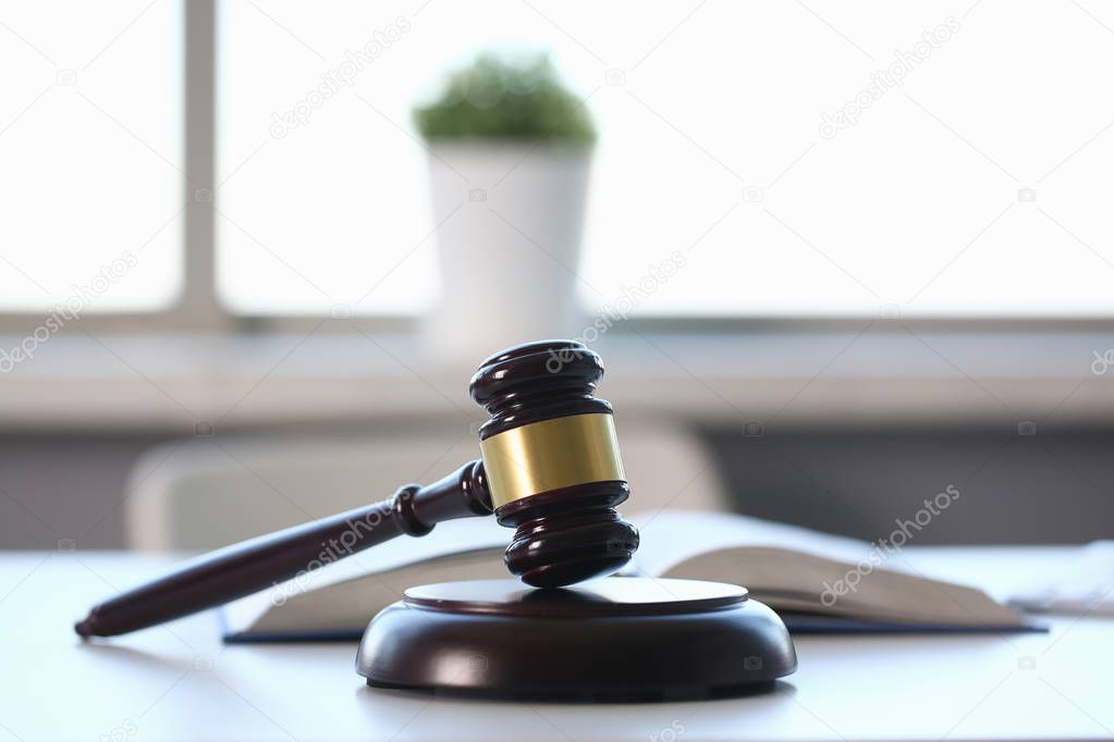 The judge hammer lies on table in