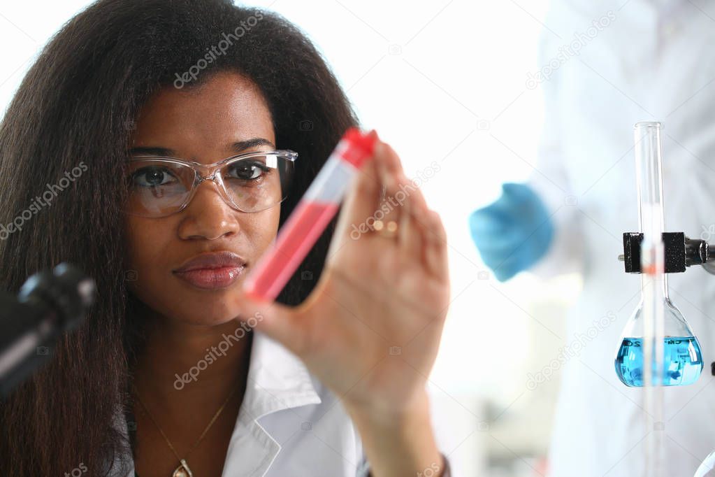 A male chemist holds test tube of glass