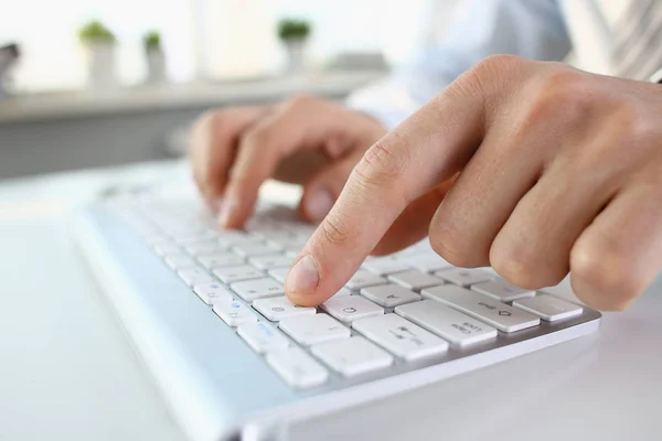 Brazos masculinos en traje escribiendo en teclado plateado — Foto de Stock