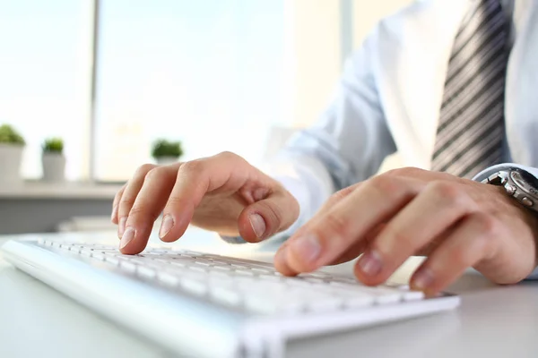 Brazos masculinos en traje escribiendo en teclado plateado — Foto de Stock