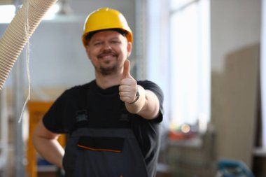 Çalışan sarı kask gösterisinde gülümseyen onaylamak işareti
