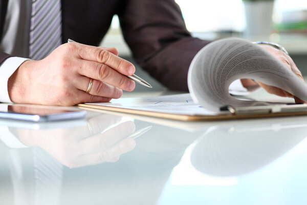 Male arm in suit and tie fill form clipped to pad