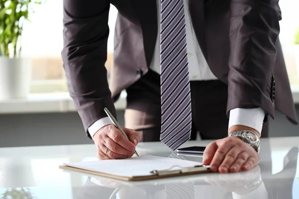 Männlicher Arm in Anzug und Krawatte füllen Formular mit Clips zum Polster — Stockfoto