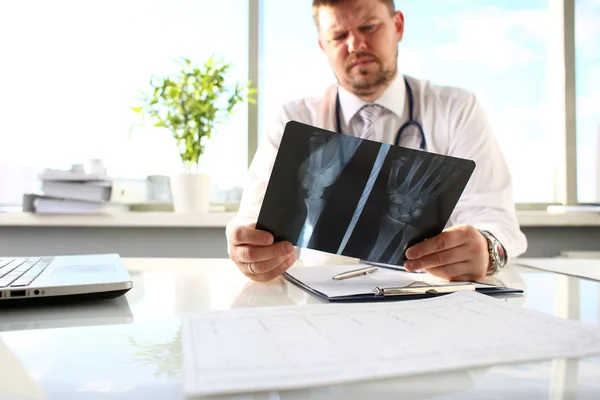 Mannelijke arts houdt in arm zilveren pen en kijken naar xray — Stockfoto