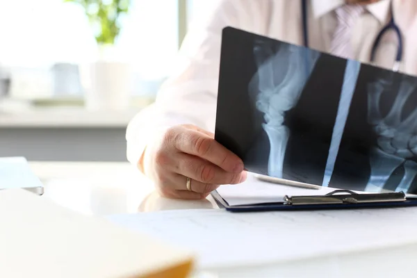 Male doctor hold in arm silver pen and look at xray — Stock Photo, Image