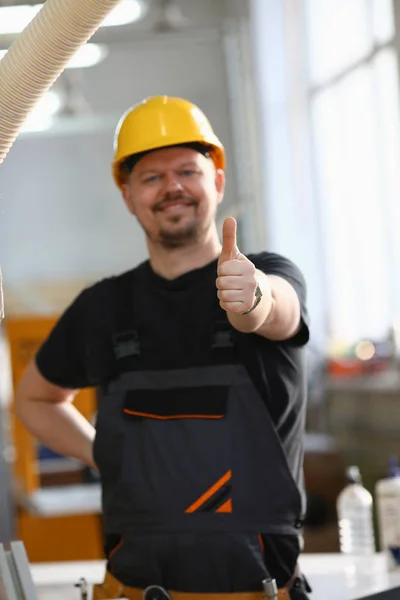 Glimlachend werknemer in gele helm Toon teken bevestigen — Stockfoto