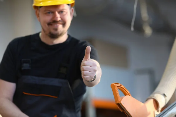 Glimlachend werknemer in gele helm Toon teken bevestigen — Stockfoto