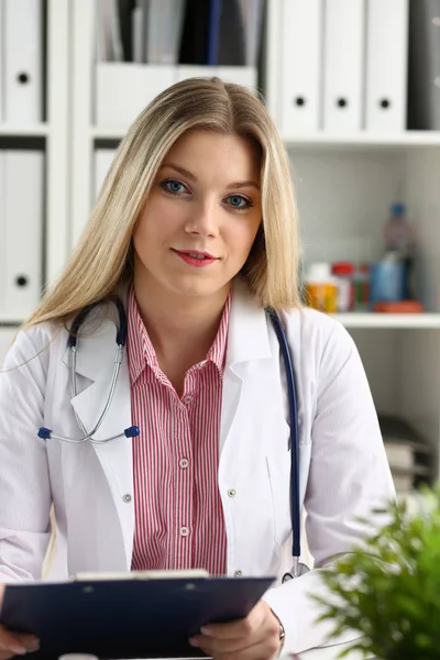 Szép női orvos mosolyogva tartsa csipeszes írótábla — Stock Fotó