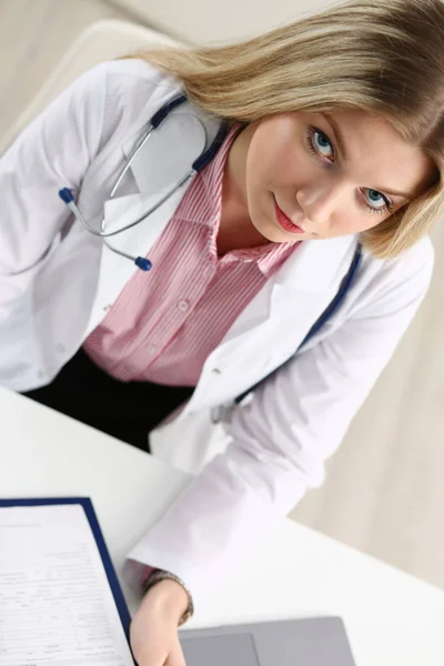 Schöne lächelnde Ärztin hält Klemmbrett — Stockfoto