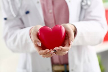 Kadın doktor kollarında tutun ve kırmızı oyuncak kapak