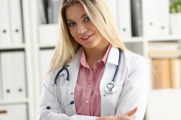 Hermosa mujer sonriente médico sentarse en el lugar de trabajo —  Fotos de Stock