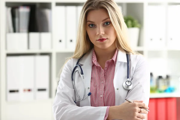 Красива усміхнена жінка-лікар сидить на робочому місці — стокове фото