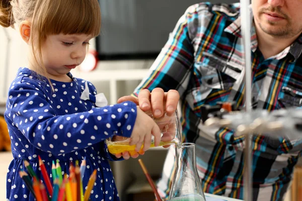 Man and little girl play with colourful liquids — Stock Photo, Image