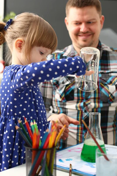 Man and little girl play with colourful liquids — Stock Photo, Image