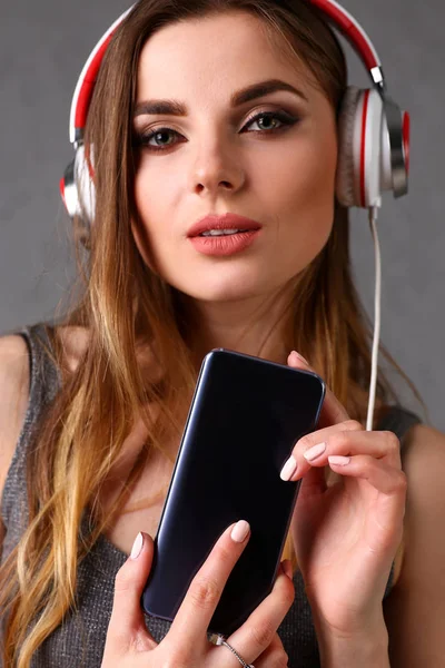 Femme dans les écouteurs tenant smartphone — Photo