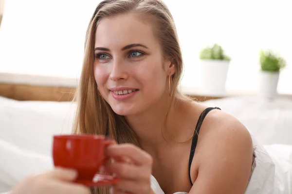금발 여자가 침대에서 차 커피를 한잔하는 모습 — 스톡 사진