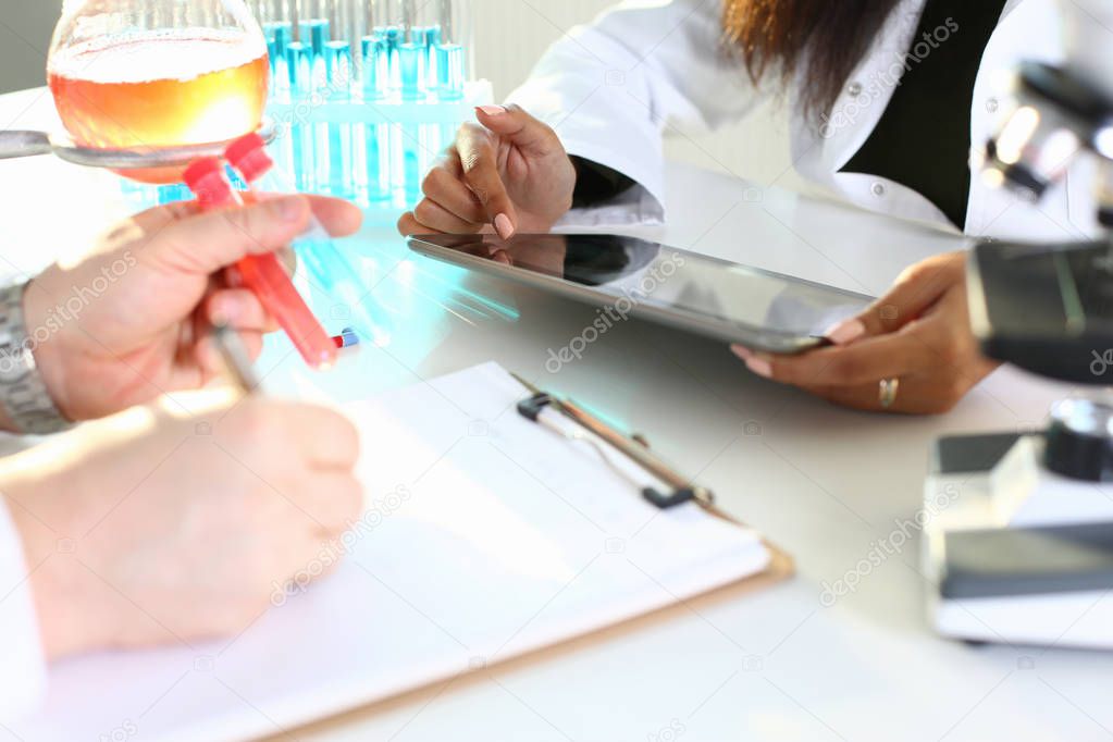 A male chemist holds test tube of glass