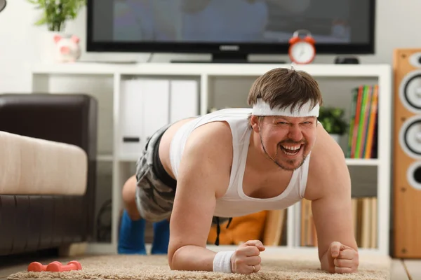 Jovem homem de fitness atraente encontra-se em um tapete de gordura com — Fotografia de Stock