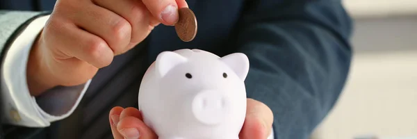 Χέρι επιχειρηματίας βάζοντας χρήματα pin σε γουρούνι — Φωτογραφία Αρχείου