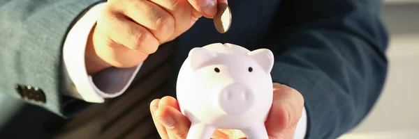 Hand businessman putting pin money into pig — Stock Photo, Image