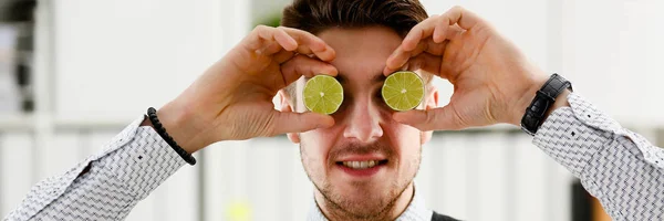 Las manos masculinas sostienen una fruta cortada a nivel de los ojos — Foto de Stock