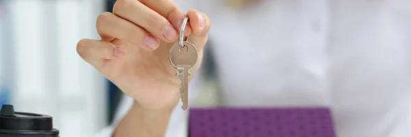 Weibliche Hand hält den Schlüssel zum Schloss in der Hand — Stockfoto