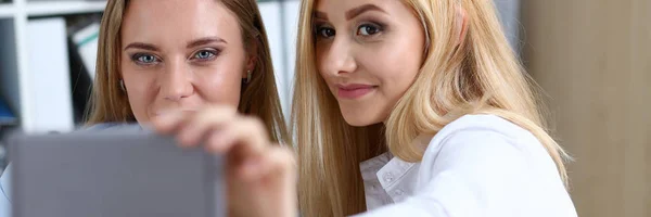 Deux femmes d'affaires dans le bureau sourient et font du selfie — Photo