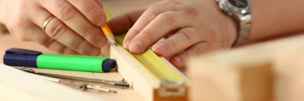 Руки працівника, що вимірює дерев'яну планку крупним планом — стокове фото