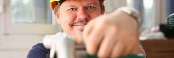 Arms of worker using electric saw closeup — Stock Photo, Image