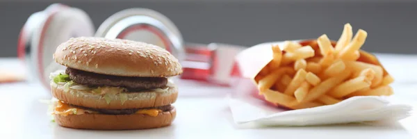 Hamburger en friet met koptelefoon — Stockfoto