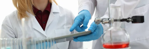 Un médico masculino en un laboratorio químico sostiene — Foto de Stock