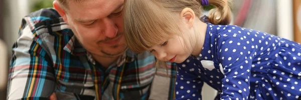 Cute little girl on floor carpet with dad use cellphone calling mom portrait. Life style apps social web network wireless ip telephony concept